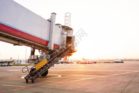 日出时在昆明长水国际机场移至飞机上的喷射桥图片