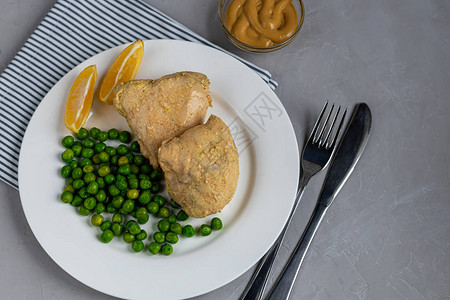 用青豆在烤箱里炖鸡胸肉膳食营养和健康的生活方式在浅灰色的背景图片