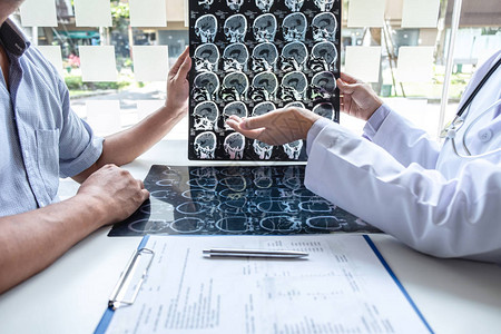 医生拿着病人的ct扫描检查大脑的x射线胶片图片