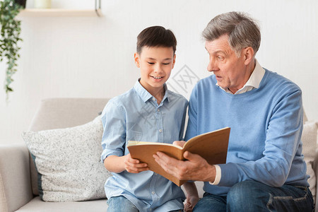 老年祖父和格外孙男孩阅读书图片