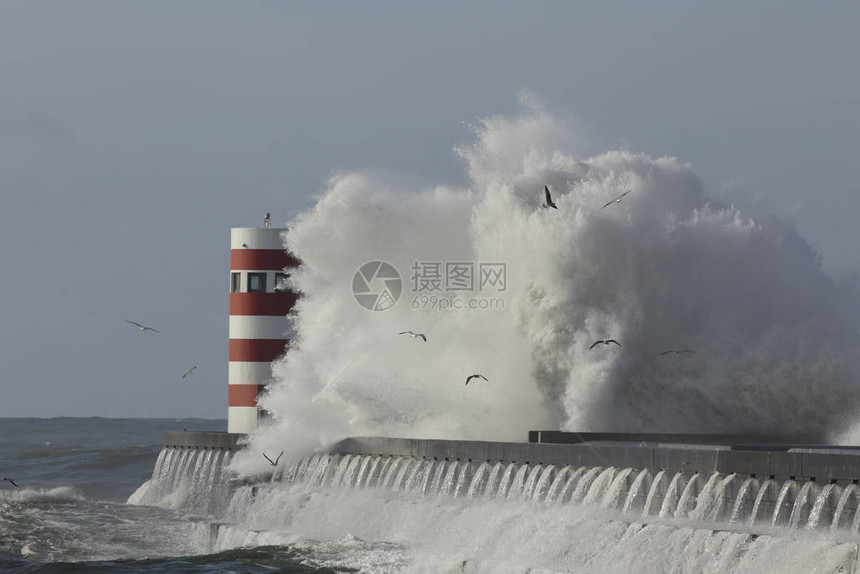 对码头和灯塔的大浪溅图片