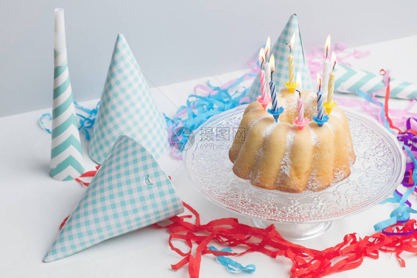 一个带有彩色燃烧蜡烛的生日蛋糕图片