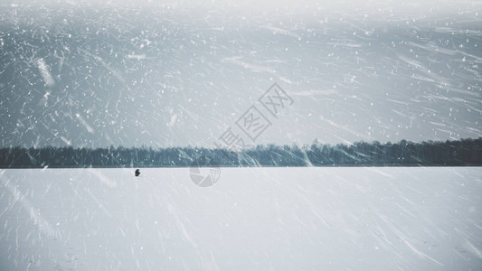一个的渔夫在结冰的湖面上冰钓图片