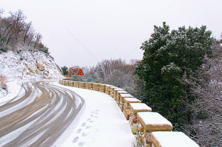 风景如画的蜿蜒小路在山间和树林中被白雪覆盖图片