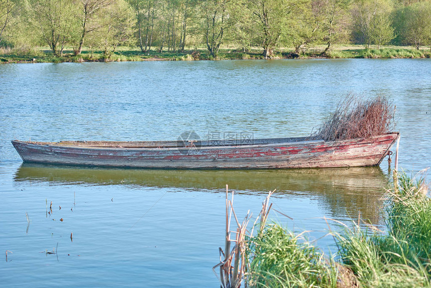 湖边的老渔船满是青草旧木图片