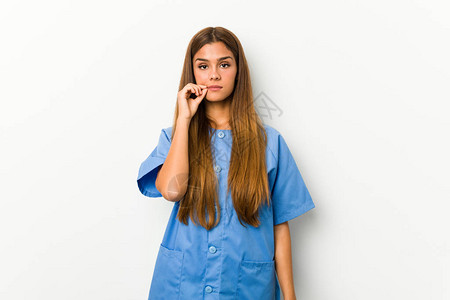 年轻的caucasian护士女人用手指在嘴唇图片