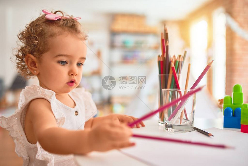 美丽的caucasian婴儿在丰富多彩的游戏室玩具图片