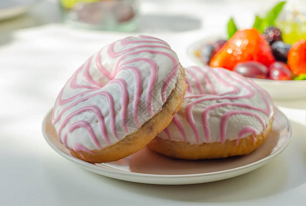 覆盆子味甜圈上面有白色和粉红色的糖背景图片