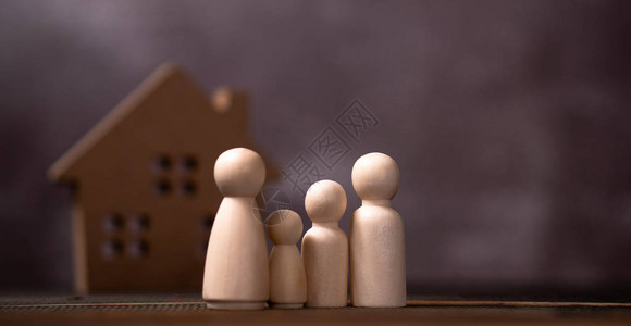站立在木房子前面的木人物家庭保护和安全家庭安全财产保险图片