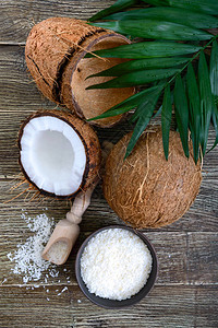 椰子整个椰子贝壳椰子片和木制背景上的绿叶大坚果带壳的热带水果椰子图片