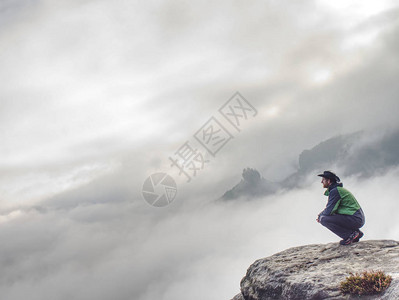孤独的人坐在悬崖上图片