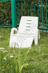 空荡的塑料白色躺椅站在绿草上图片
