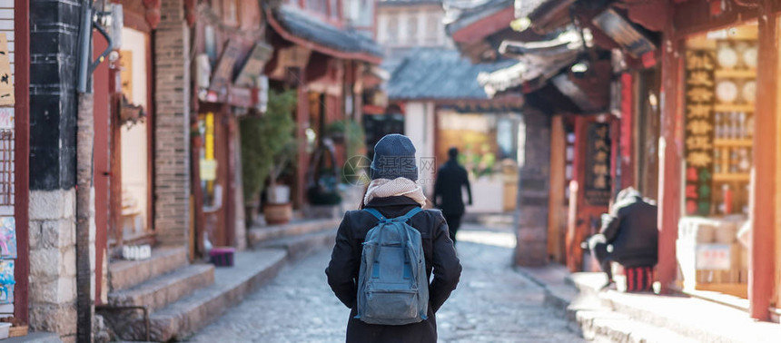 年轻女子旅行者在丽江古城广场街旅行图片