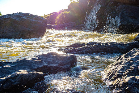 山河水在石头之间迅速流淌的溪流中图片