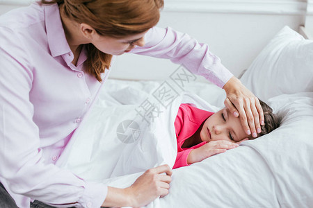 怀着焦虑的母亲用发烧的昏睡女图片