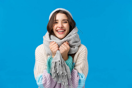 穿着冬季毛衣帽子和围巾的快乐开朗魅力四射的女人图片