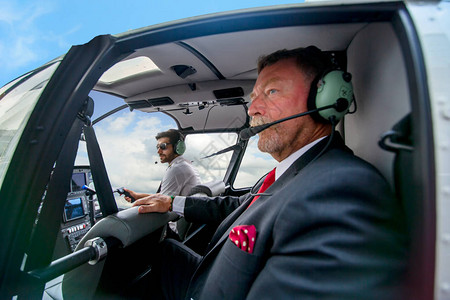 乘坐直升机旅行的商务人士图片