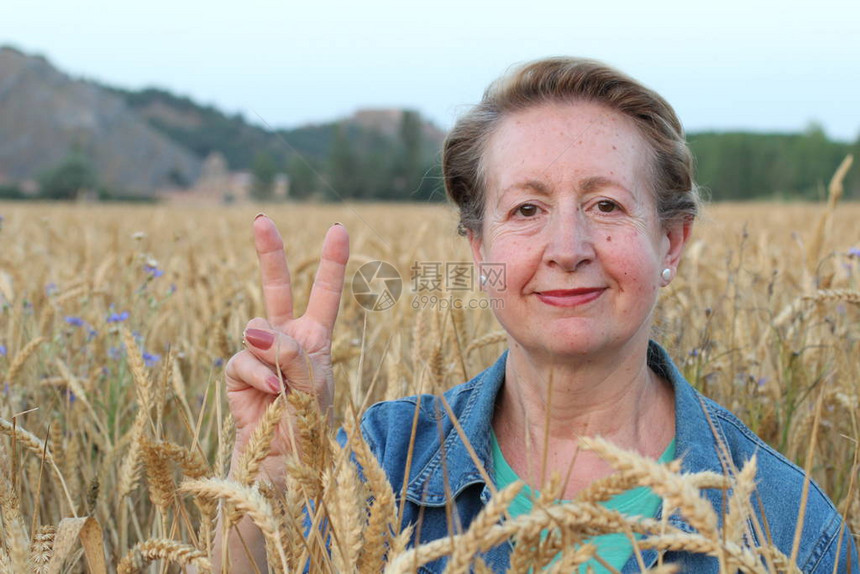 享受自然日落的自由女人自由与宁静的概念与成熟的自然女模特60多岁的白人女模特在