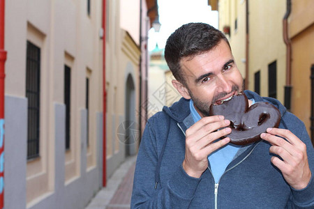 吃心形巧克力酥皮点心的男人图片
