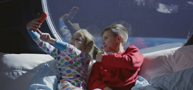 一个男孩和一个女孩在宇宙飞船上自拍的中景图片