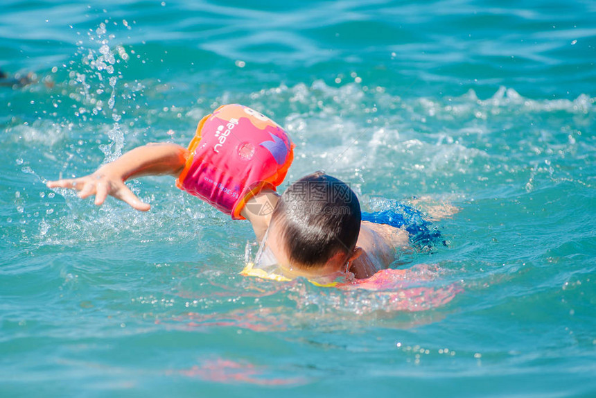 小孩子在海里戴臂章游泳儿童游泳训练图片