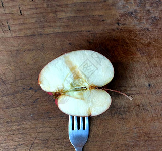 木板上有一块苹果的叉子健图片