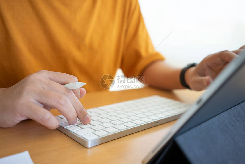 年轻的自由职业者或商人在家庭办公室工作并在键盘智能手机平板电脑上打字在使用智能手机平板电脑时在线工作或学习和学习自由职图片