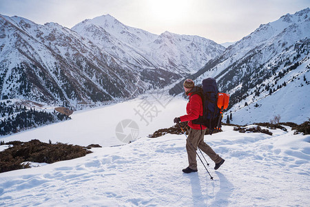 在冬天的山上徒步旅行一名游客在冬天在山上散步旅行者是在一个结冰的图片