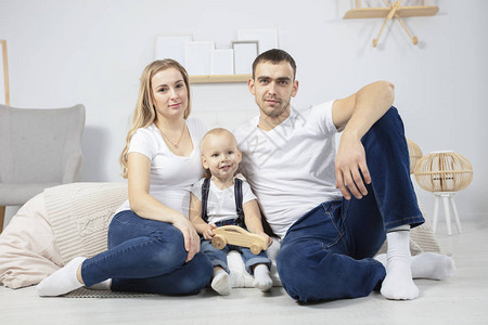 家庭爸妈孩子在家坐在地板上肖像丈夫妻子和小儿子夫妇在图片