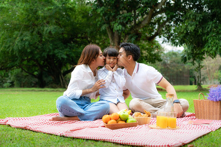 亚洲青少年家庭在公园里度过快乐的假期野餐时刻图片