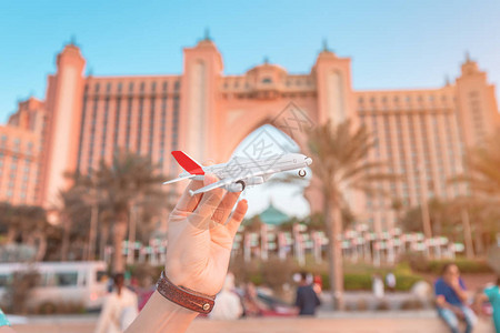 旅游女孩在迪拜海上度假胜地酒店的背景下玩具白色客机航空旅行图片