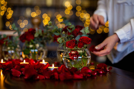 用玫瑰花瓣和蜡烛装饰节日餐桌的过程图片