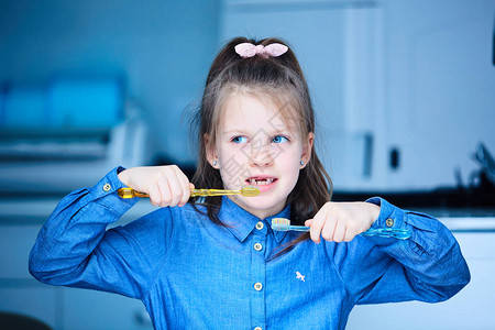 一个可爱的小女孩用两支牙刷图片
