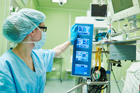 外科助理灌注师在心脏病诊所手术室操作现代心肺机和图片