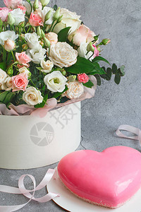 礼品套装粉色心形慕斯蛋糕和灰色垃圾背景上的一大束美丽花朵情人节图片