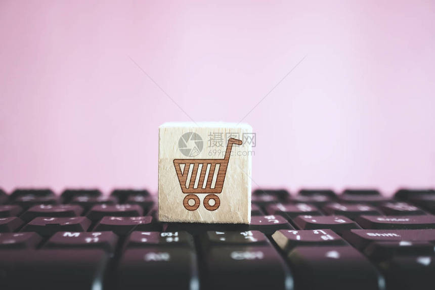 计算机键盘上的木板上封闭的购物车图标在线商店业技术概念您可图片