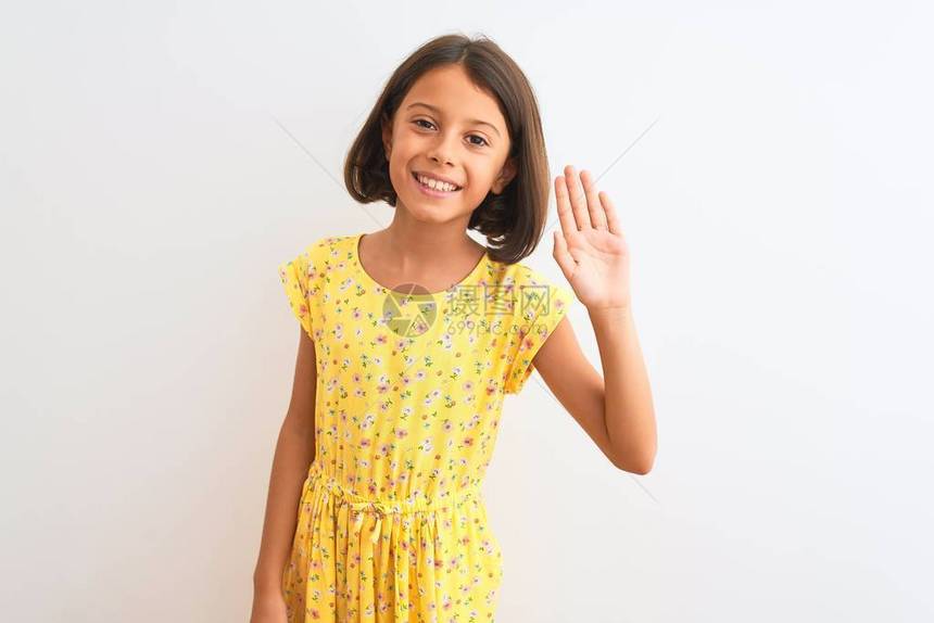 身穿黄色花裙的年轻漂亮小女孩站在孤立的白色背景上放弃打招呼快乐微笑友图片