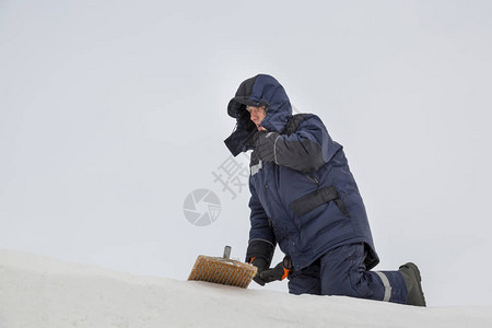 建造者用钢丝刷从雪中清洁冰板图片