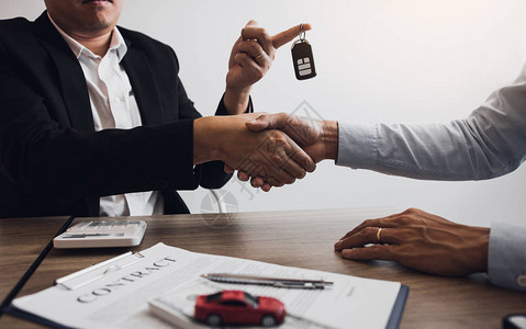 新车买家和汽车销售员握手就汽车销售图片