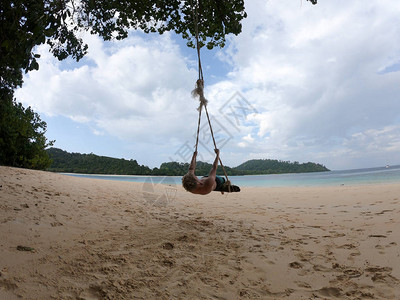 活跃的男孩在泰国享受海滩摇摆图片