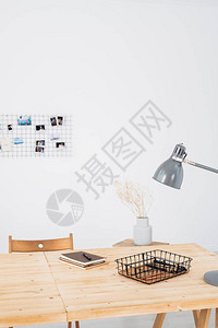 带灯的木桌盆栽植物带笔的记本和办公室白墙背景图片