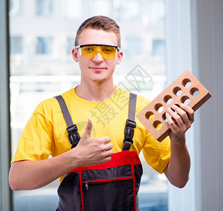 黄色工作服的年轻建筑工人图片