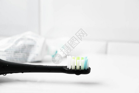 背景上有牙膏的电动牙刷和管子图片