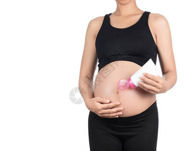 孕妇肚子上擦奶油的乳霜在白种图片