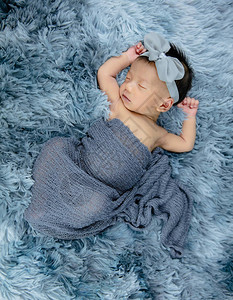 可爱的新生儿穿着灰羊毛地毯领首图片