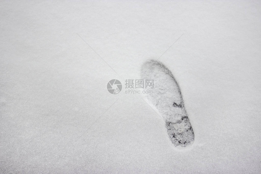 洁白的冬雪上清晰的深脚印俯视图雪面纹理雪地上的人类脚印自然的冬天背景雪地里的鞋印走在图片