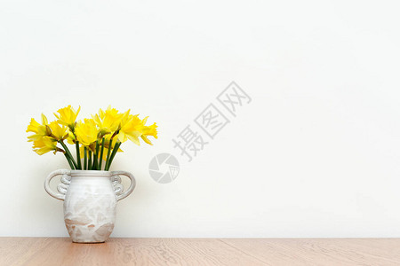 木制桌边有白色内墙背景的鲜花背景图片