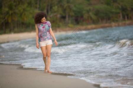 混血的女人站在海边的冲浪线上图片