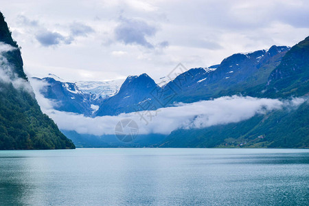 美丽的Oldevatnet冰川湖和雾山的景观背景图片