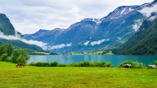 美丽的Oldevatnet冰川湖和雾山的景观背景图片